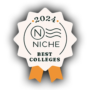 A badge-shaped emblem with a white background and gold ribbon-like edges. The text "2024 N Niche Best Colleges" is displayed in the center in green and gold font, with the "N" surrounded by a circular outline and wavy lines on the right side.